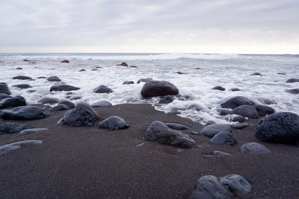 חול שחור בטנריף וסלעים בים