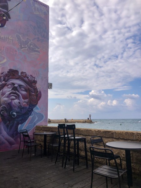 פינות ישיבה מול הים בנמל עכו ולצד גרפיטי