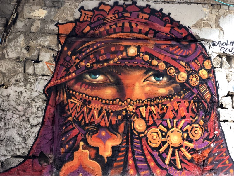 ציור גרפיטי של אישה מכוסה על קיר